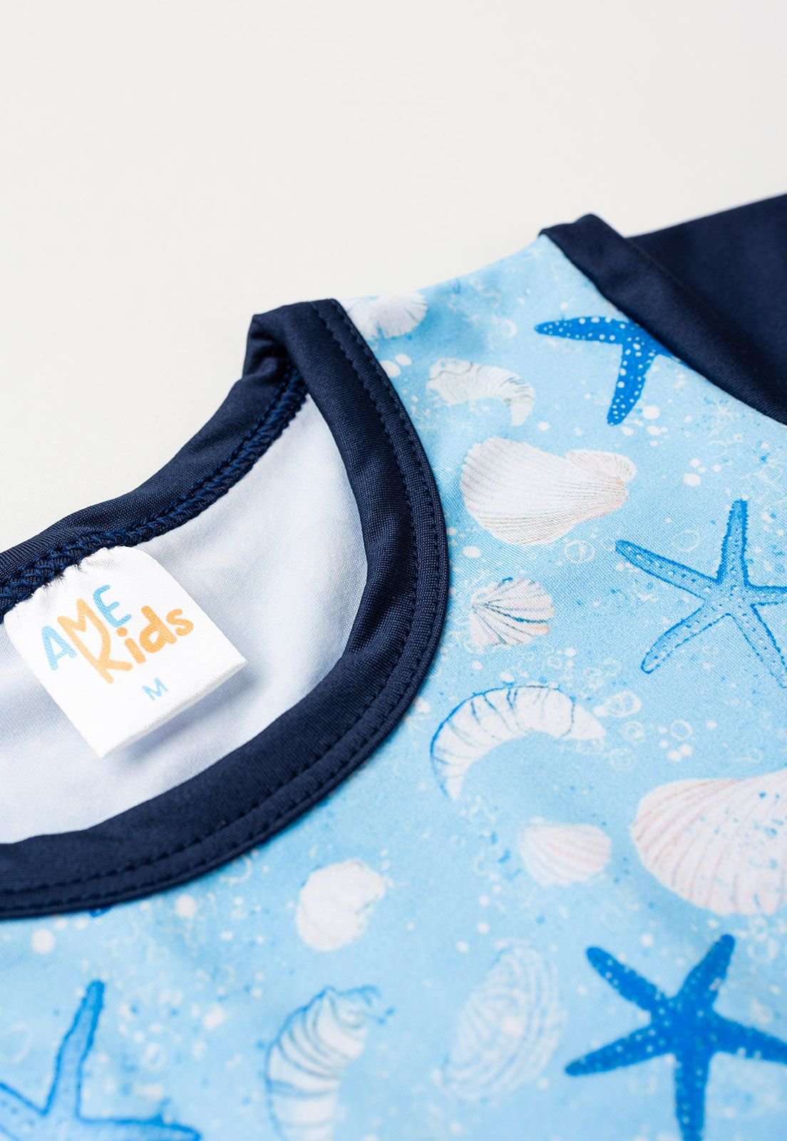Detalhe: Estampa na frente do Conjunto Blusa e Shorts com Prote&ccedil;&atilde;o UV Ame Kids, cor Azul Marinho