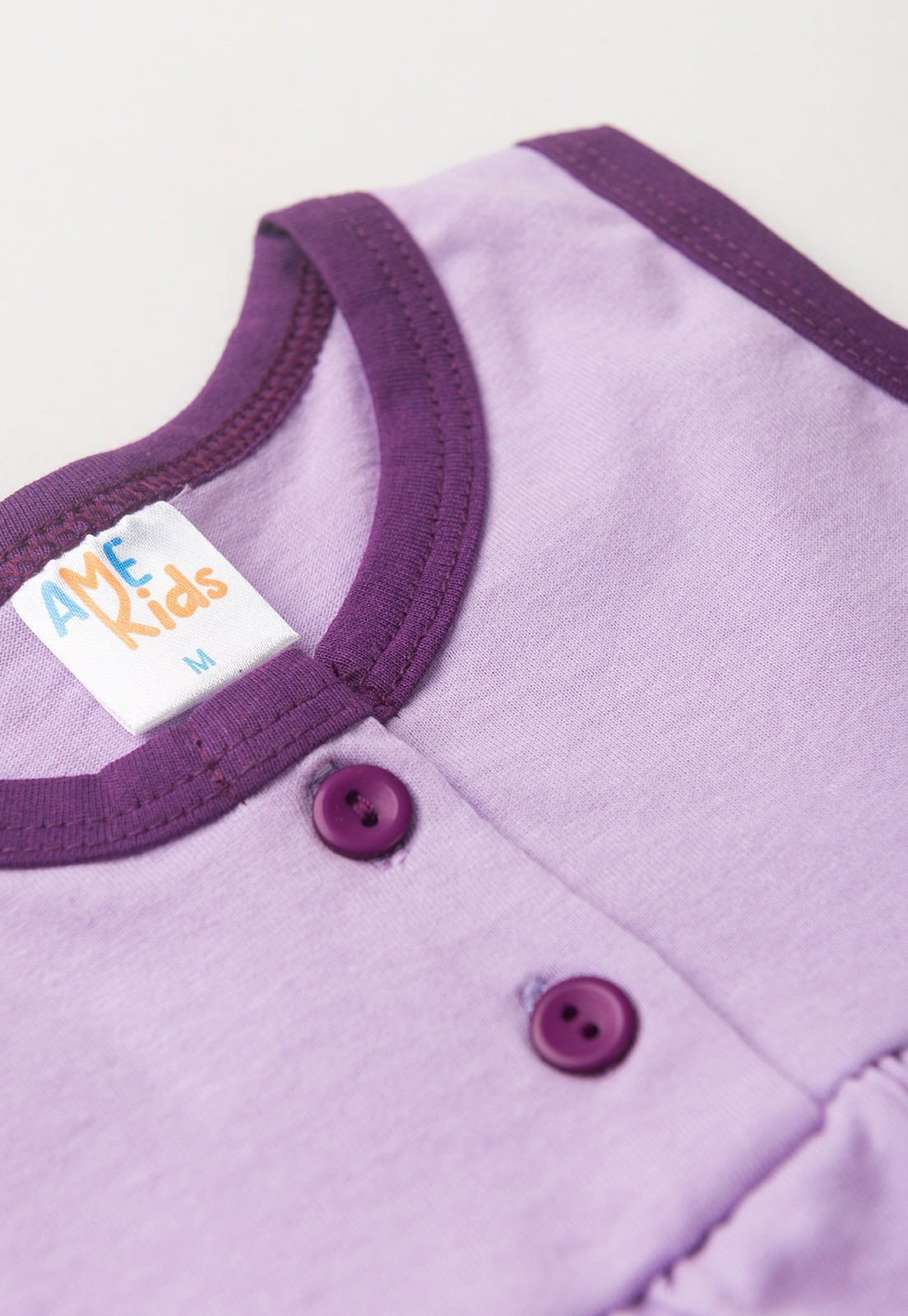 Detalhe: Vi&eacute;s e bot&otilde;es do Conjunto Bata e Shorts Ame Kids, cor Beringela