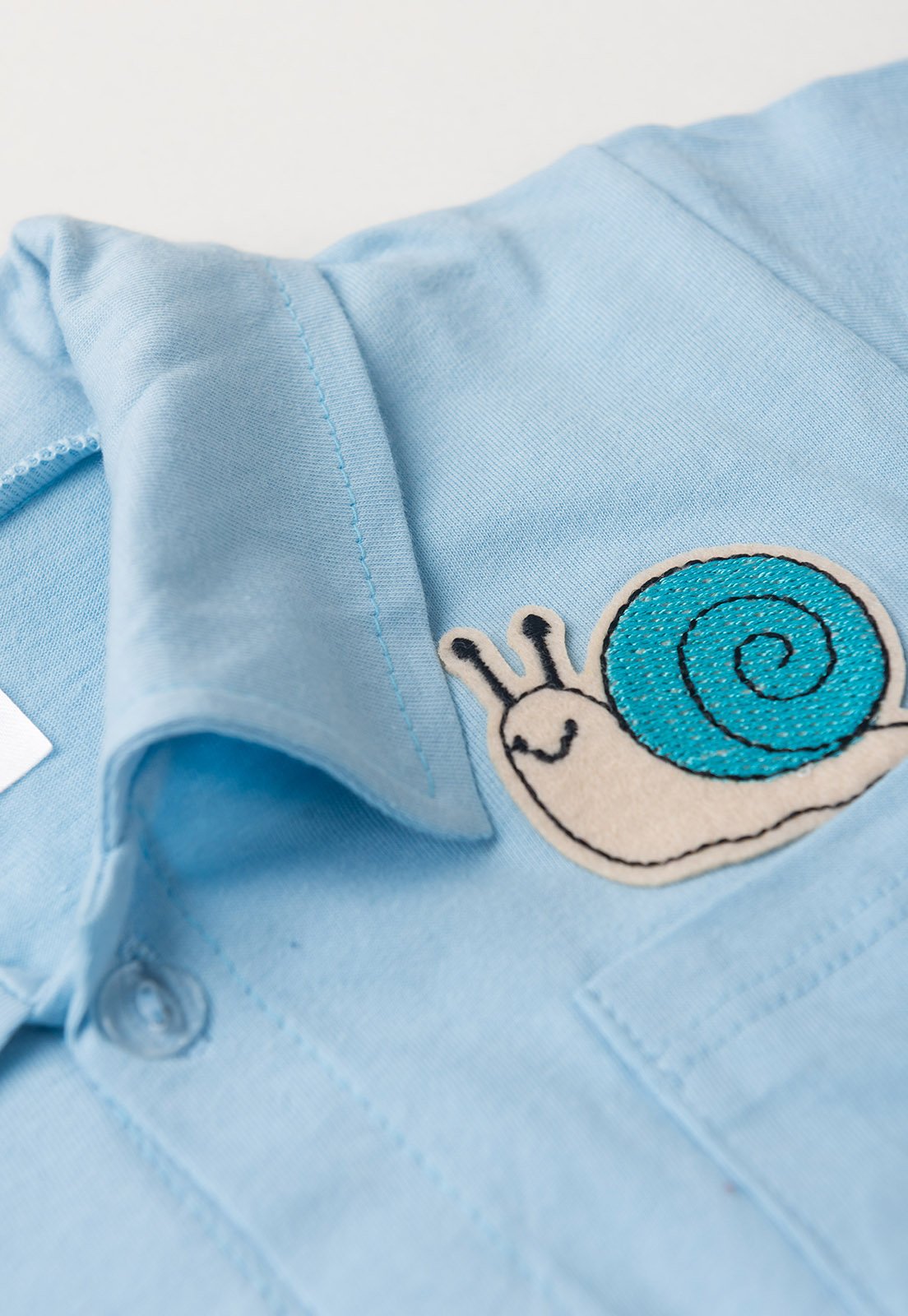 Detalhe: Bolso bordado do Conjunto Camisa e Shorts Ame Kids, cor Azul Beb&ecirc;