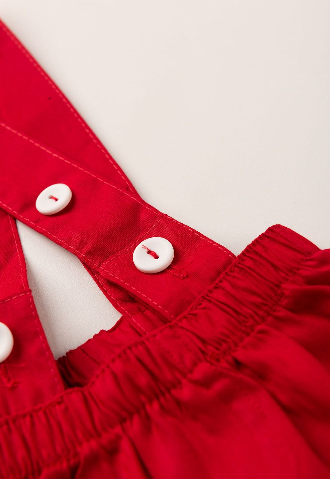 Detalhe: Bot&otilde;es nas al&ccedil;as da Jardineira de Tricoline Ame Kids, cor Vermelho