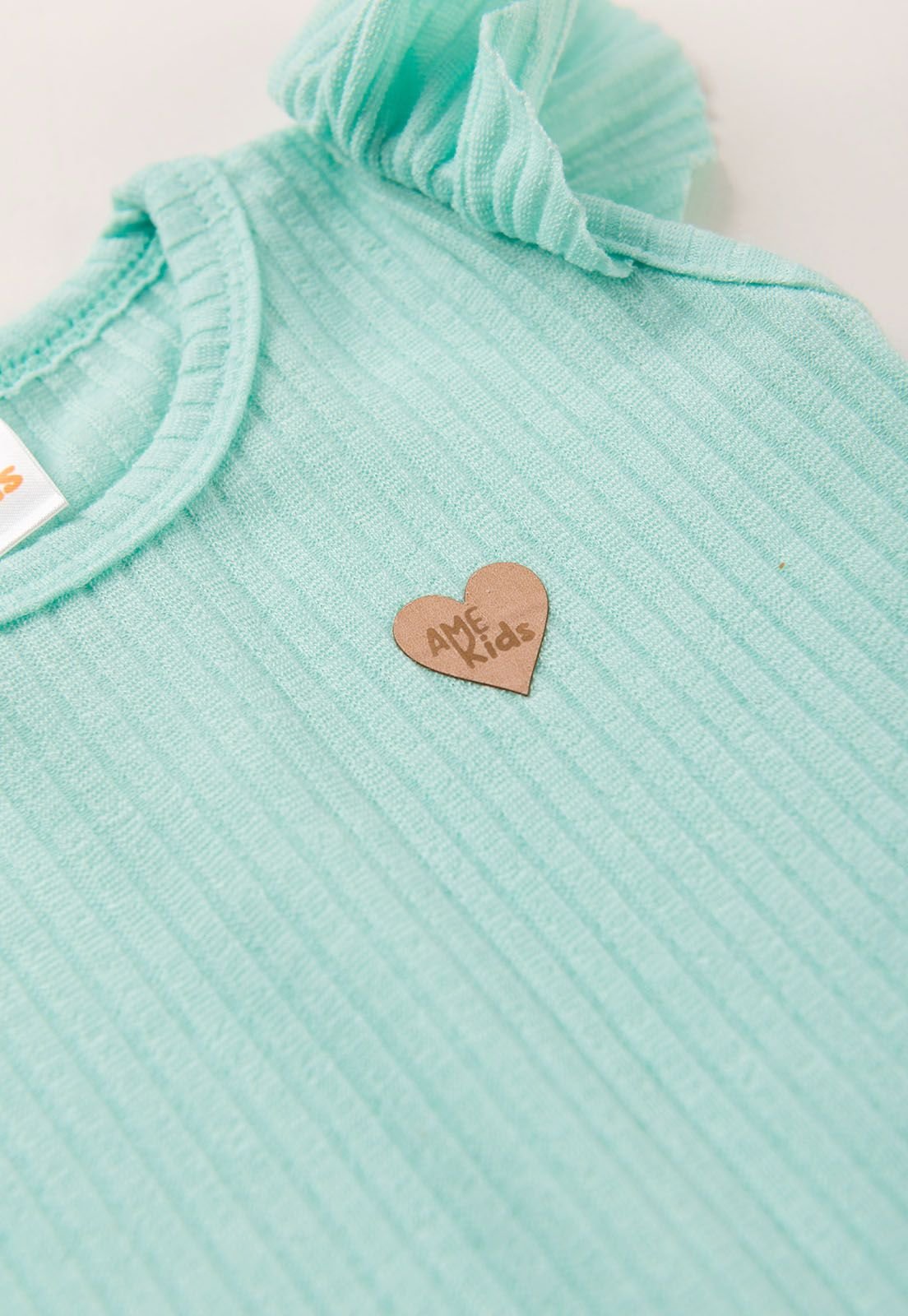Detalhe: Cora&ccedil;&atilde;ozinho no peito do Conjunto Body e Shorts Canelado Xadrez Ame Kids, vers&atilde;o Xadrez Tie Dye