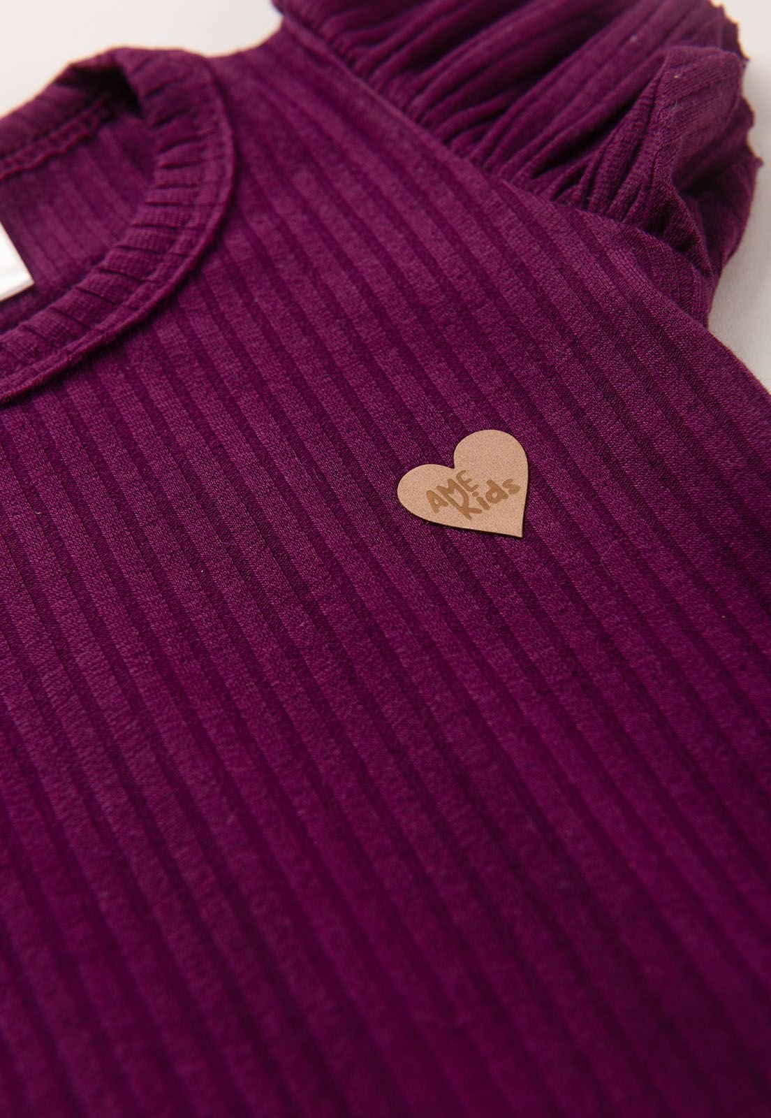 Detalhe: Cora&ccedil;&atilde;ozinho no peito do Conjunto Body Canelado e Saia Floral Ame Kids, cor Beringela
