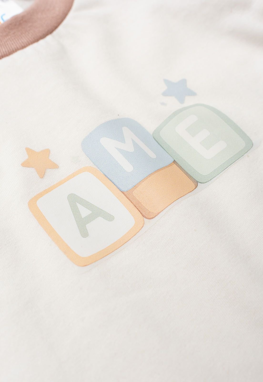 Detalhe: Estampa frontal do Pijama Blusa Raglan e Cal&ccedil;a Estampado Ame Kids, cor Doce de Leite
